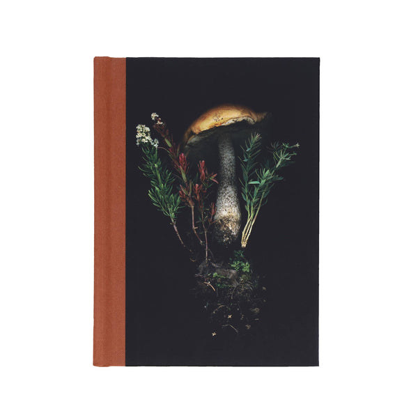 Notebook with a mushroom and plant design on a black background