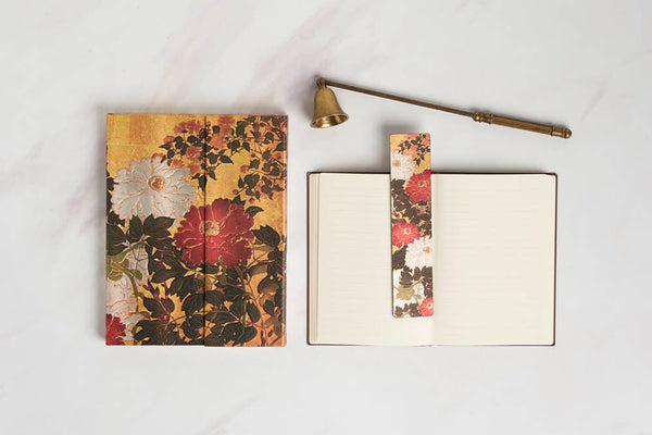 Floral notebook with a brass lamp on a light background
