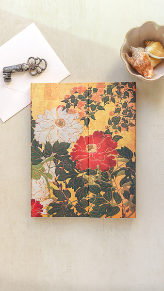 Floral notebook on a light surface with a key and small dish in the background