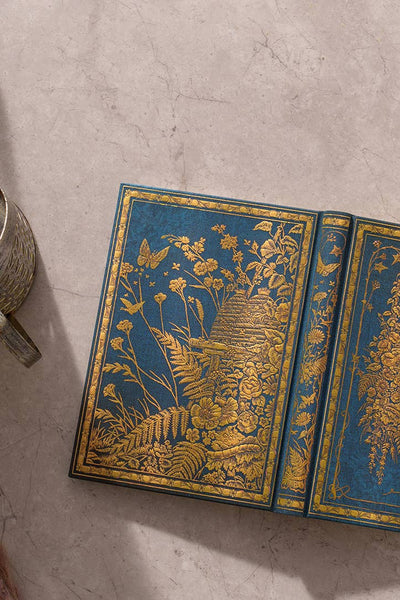 Decorative book with gold floral patterns on a textured surface